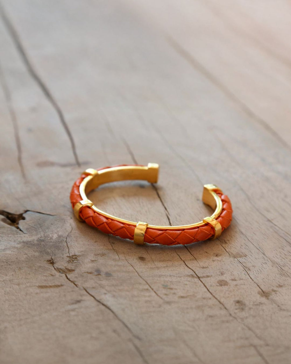 Our Lisbon bracelet in orange braided lambskin seen from the quarter in ambiance.