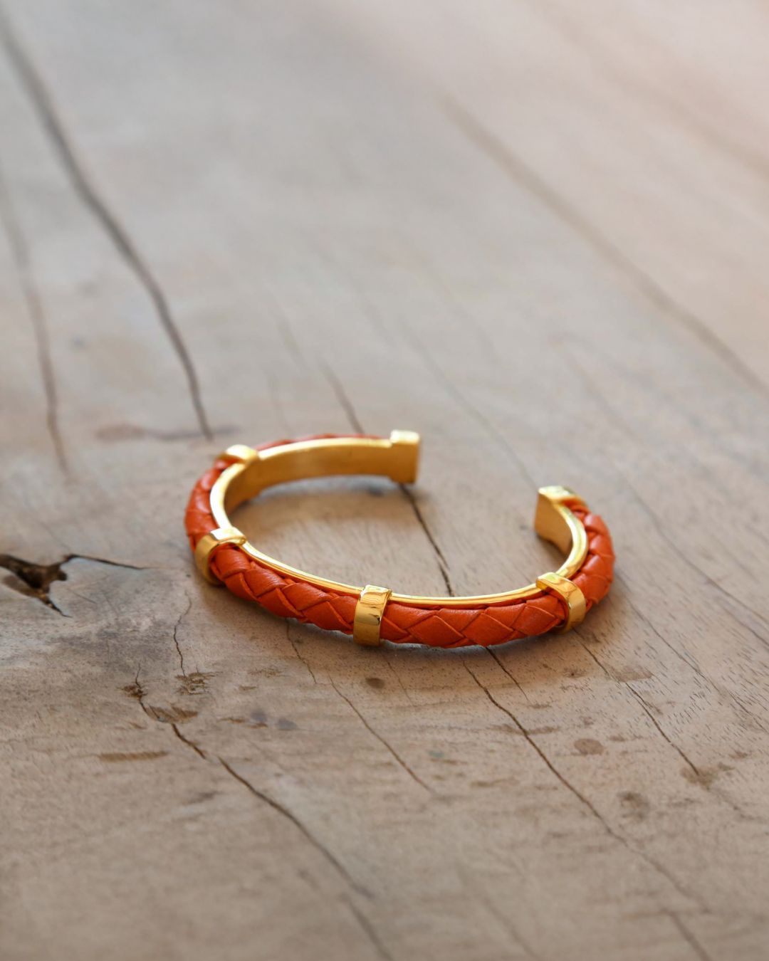Notre bracelet Lisbonne en cuir d'agneau tressé orange vu de quart en ambiance.