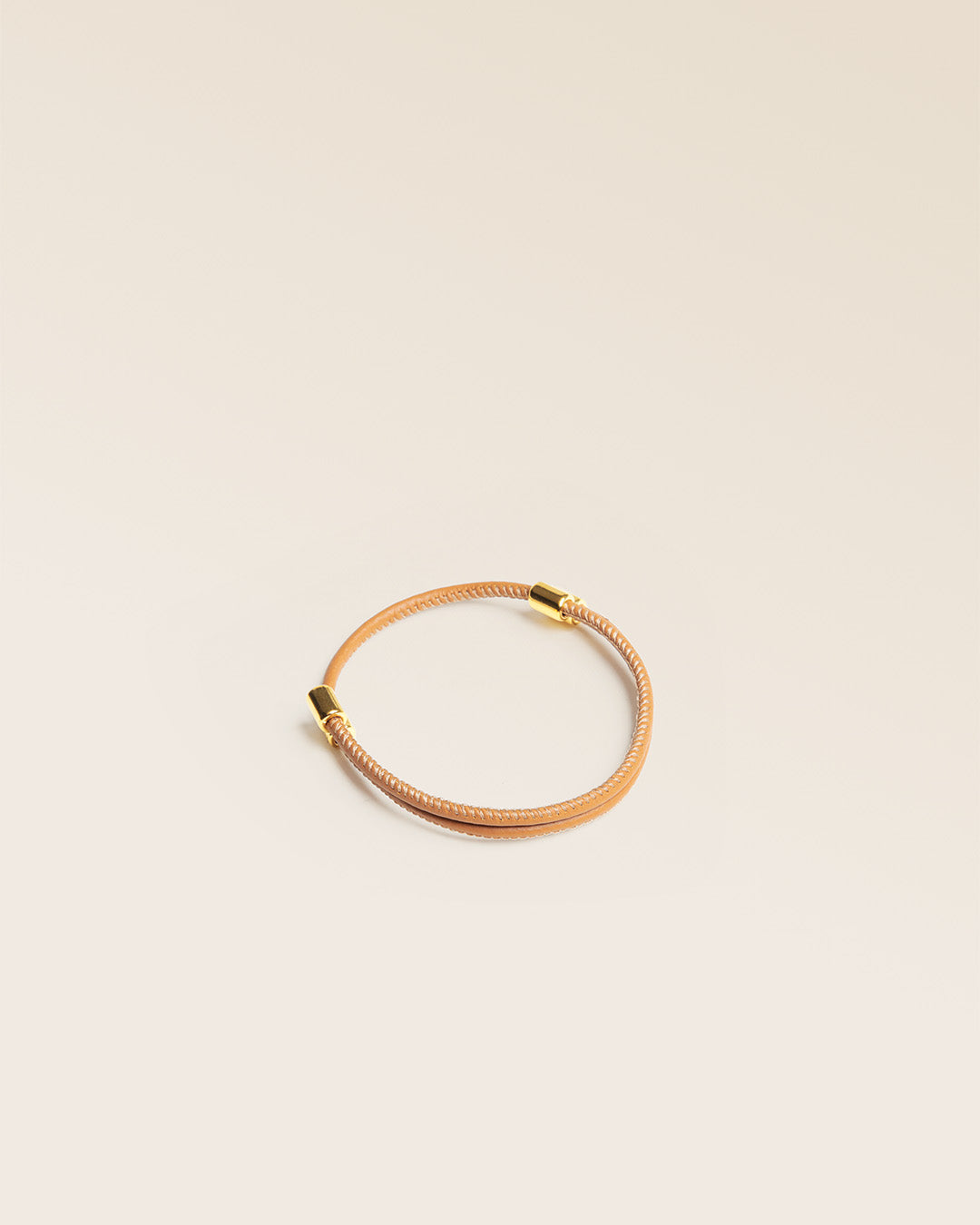 Notre bracelet Mia en cuir d'agneau camel vu de quart en studio.