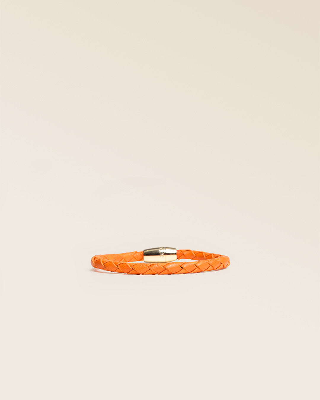 Notre bracelet Mohican en cuir d'agneau tressé orange vu de face en studio.