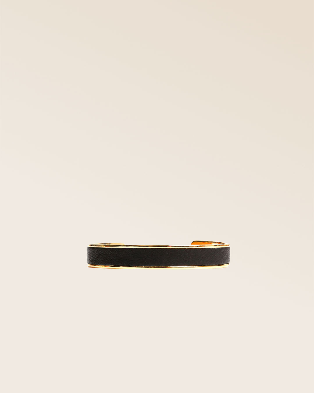 Our Pacôme Renouard bracelet in gilded metal and smooth black leather, seen from the front in the studio.