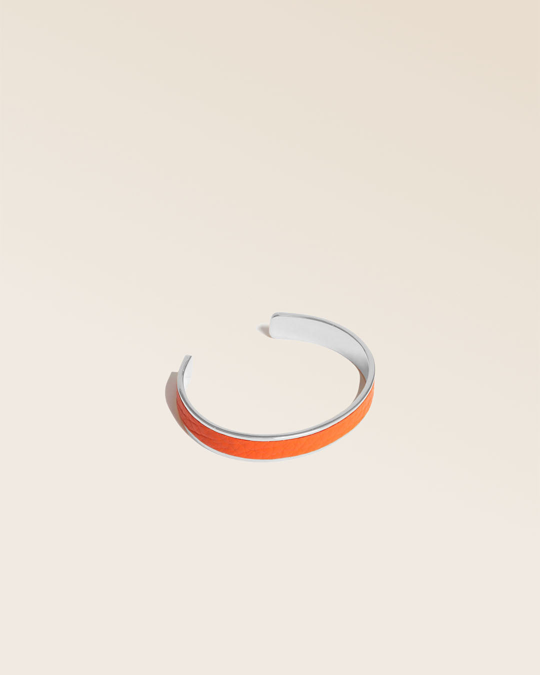 Our golden Pacôme bracelet in orange vicuña-style leather, seen from the quarter in the studio.