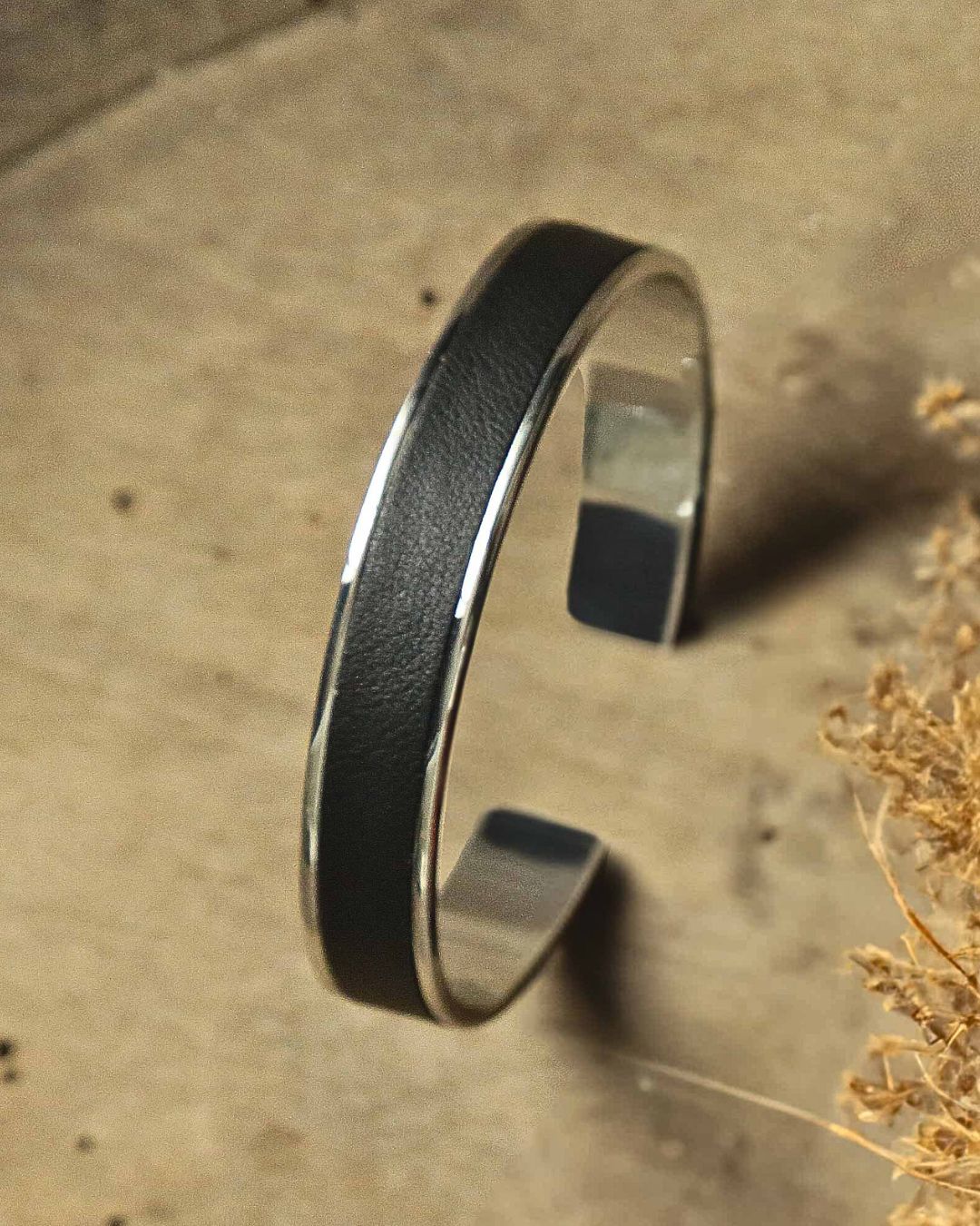 Our Pacôme Renouard bracelet in nickel-plated metalwork and smooth black leather, seen in ambiance.