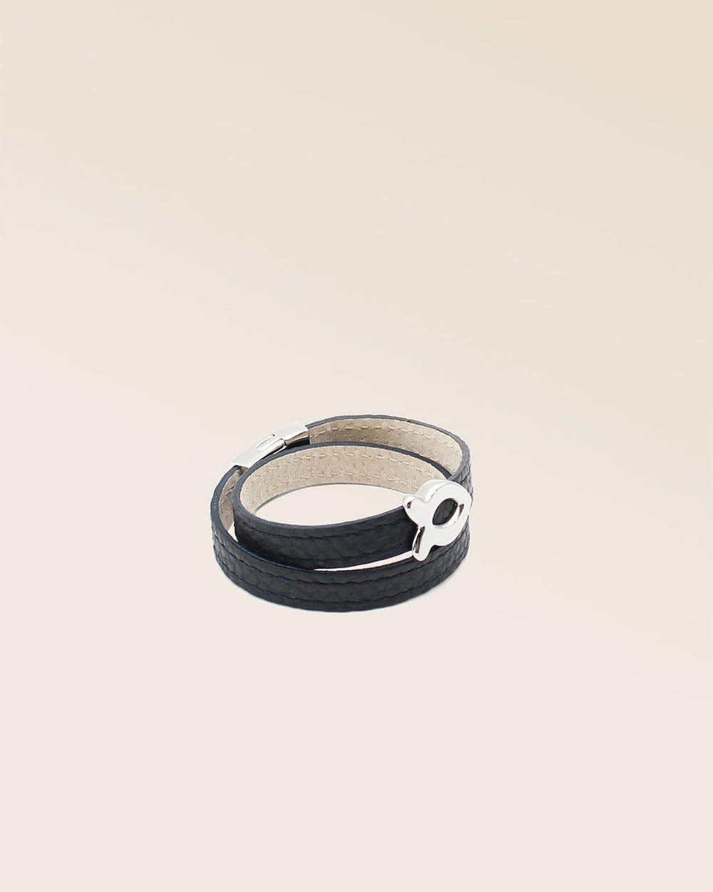 Notre bracelet Sardine nickelé en cuir façon vigogne bleu marine vu de quart en studio.