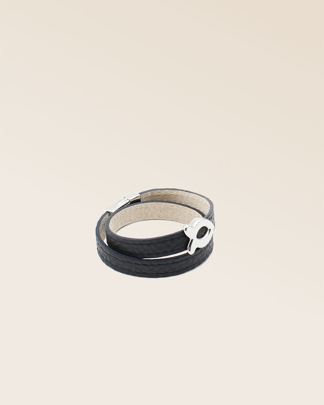 Notre bracelet Sardine nickelé en cuir façon vigogne bleu marine vu de quart en studio.
