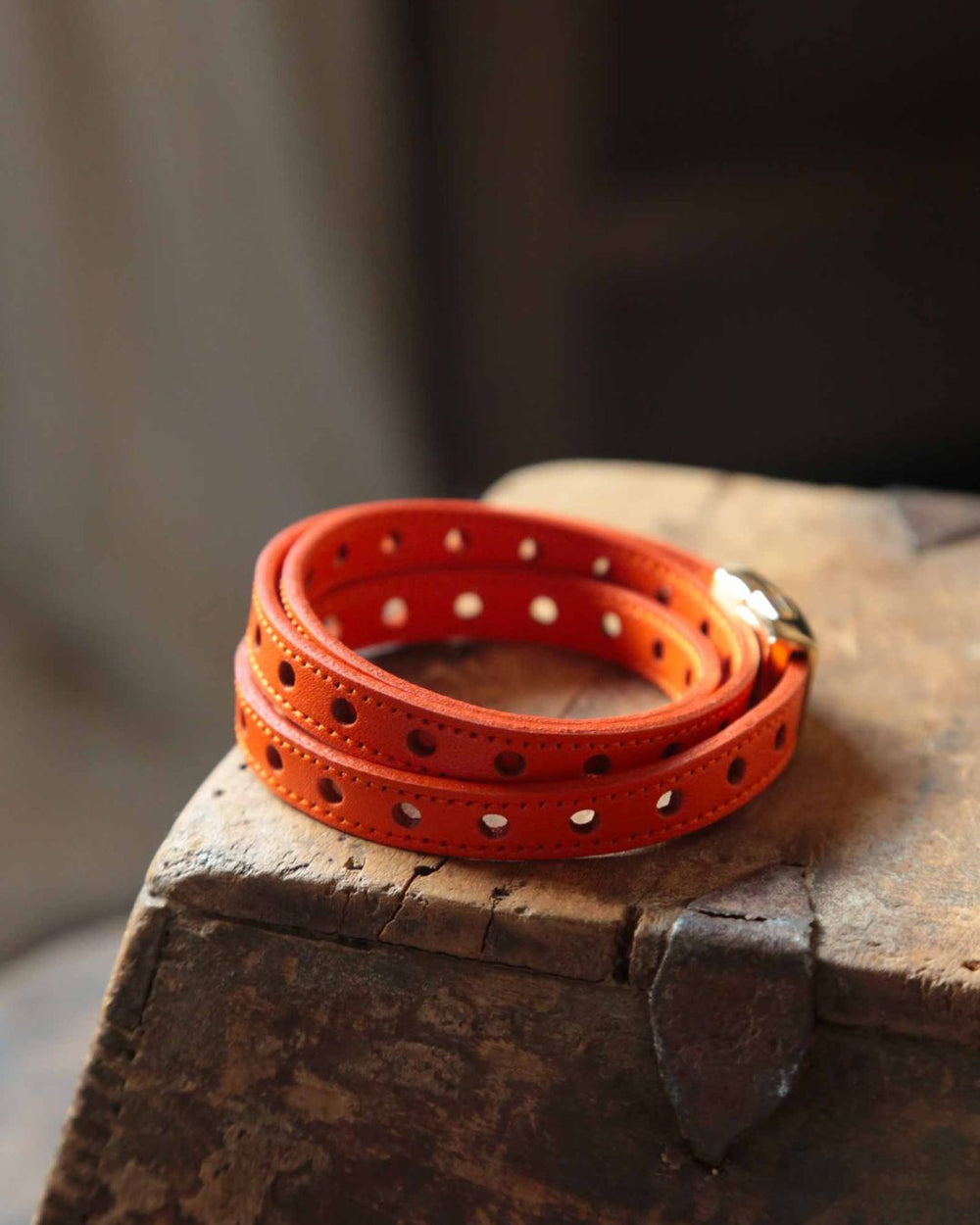 Notre bracelet Totem en cuir d'agneau perforé orange vu de quart en ambiance.