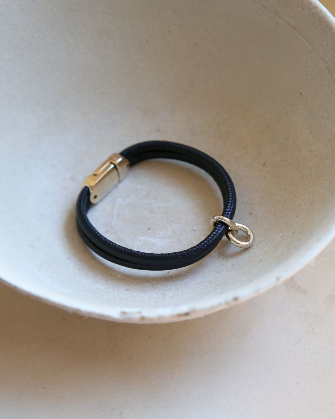 Notre bracelet Twin en cuir d'agneau noir vu de quart en ambiance.