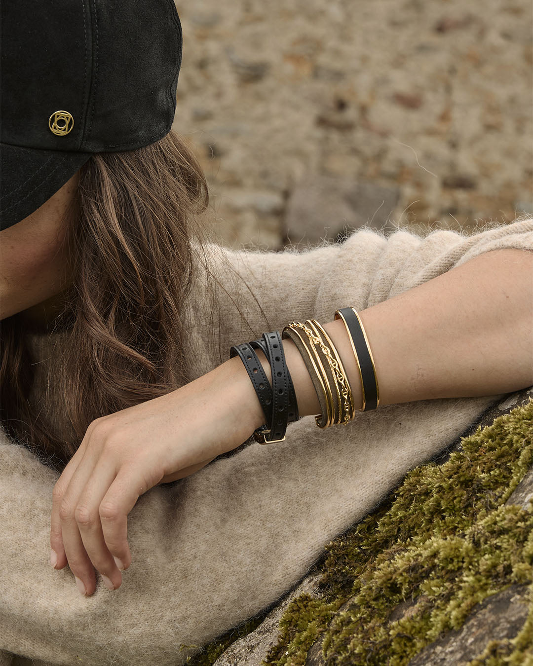 Notre bracelet Pacôme Renouard en métail doré et cuir lisse noir, vu porté par notre mannequin.