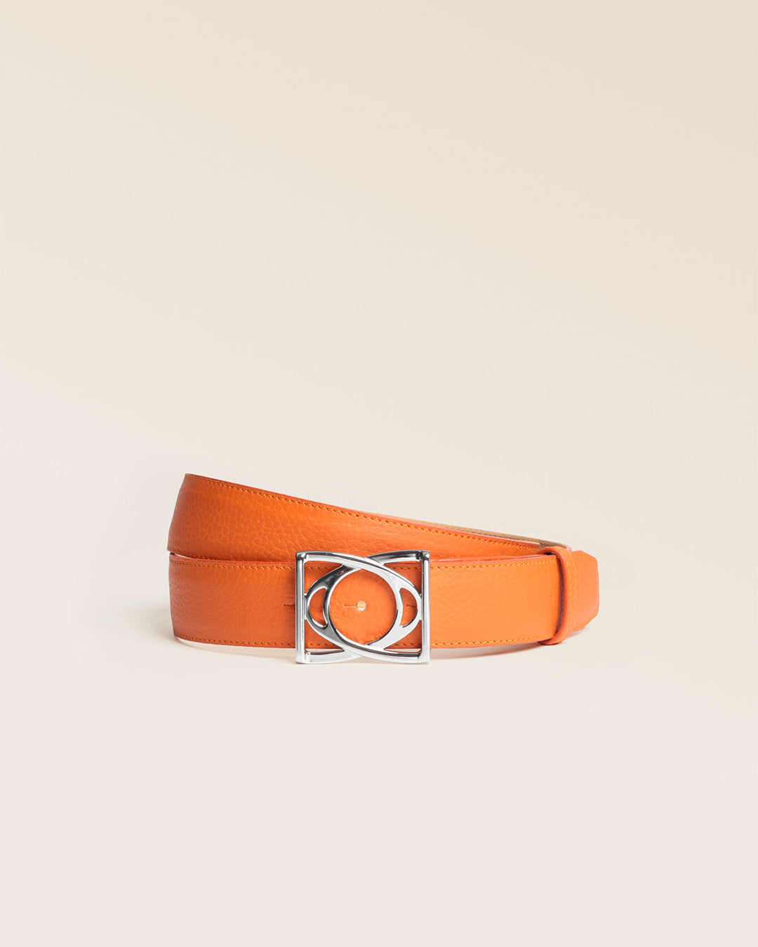 Our Cabriole belt in orange vicuña-style leather, seen from the front in the studio.