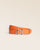 Our Cabriole belt in orange vicuña-style leather, seen from the front in the studio.