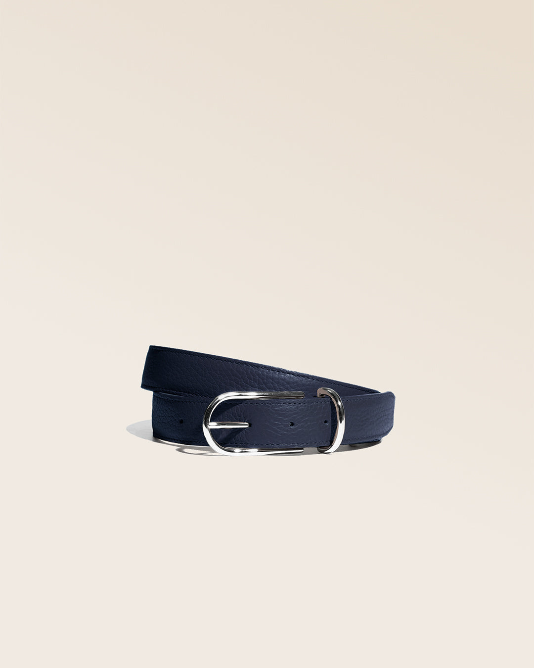 Notre ceinture Marina Renouard, en cuir façon vigogne bleu marine, vue de face en studio.