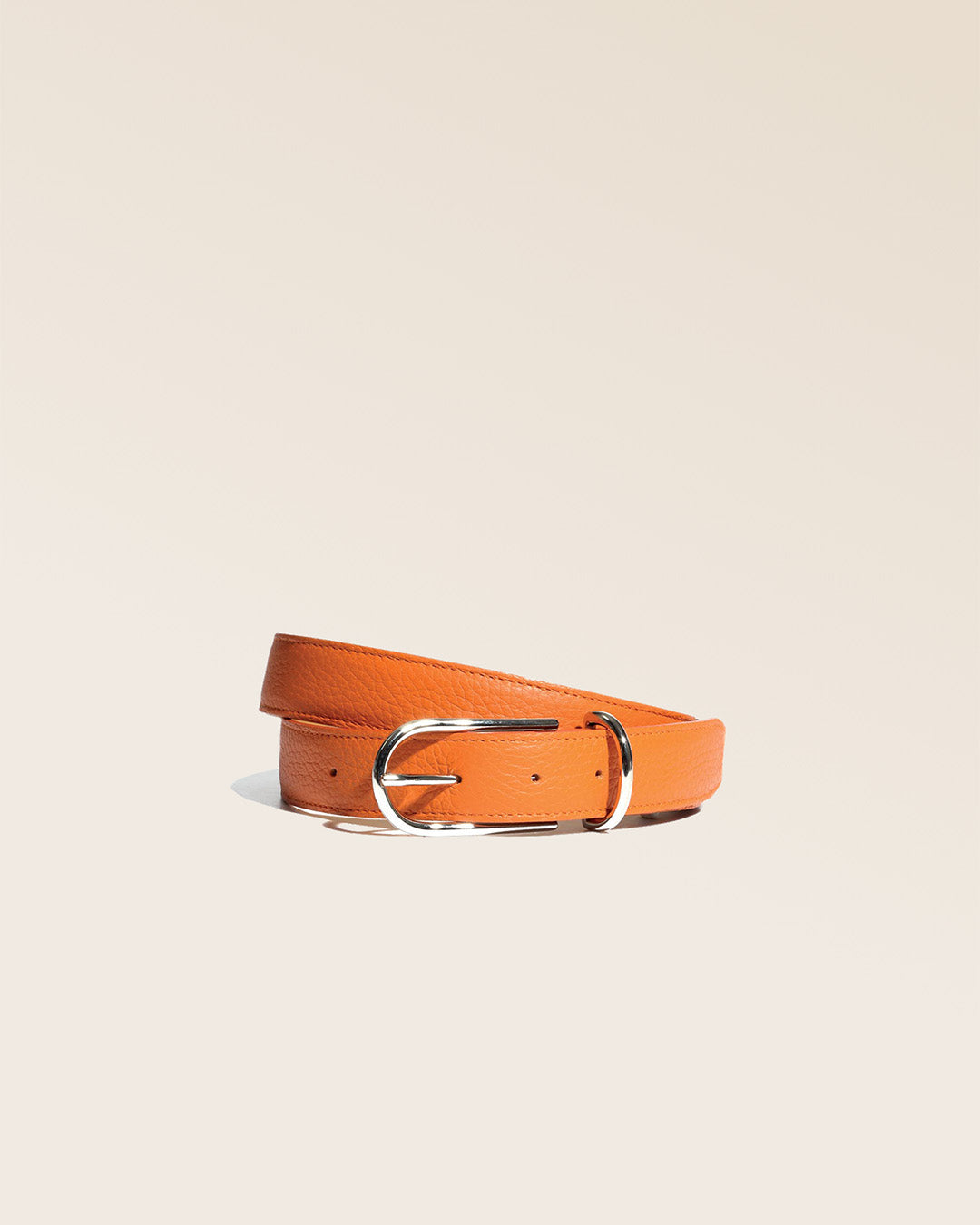 Notre ceinture Marina en cuir façon vigogne orange vu de face en studio.