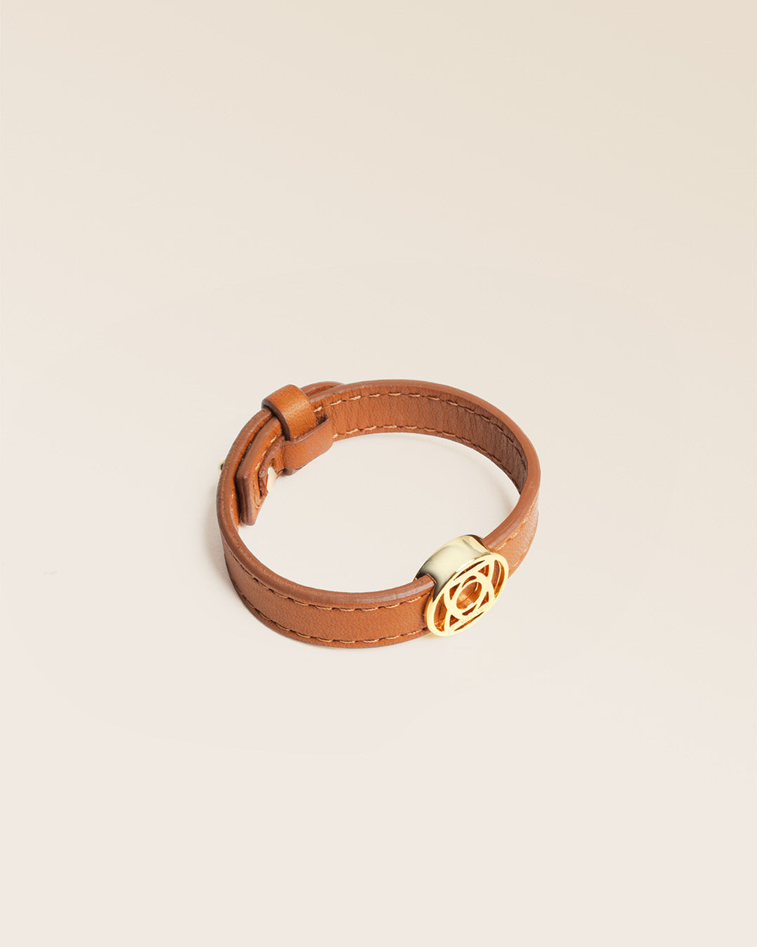 Notre bracelet Alezan en cuir vintage camel et accessoire doré vu de quart en studio.