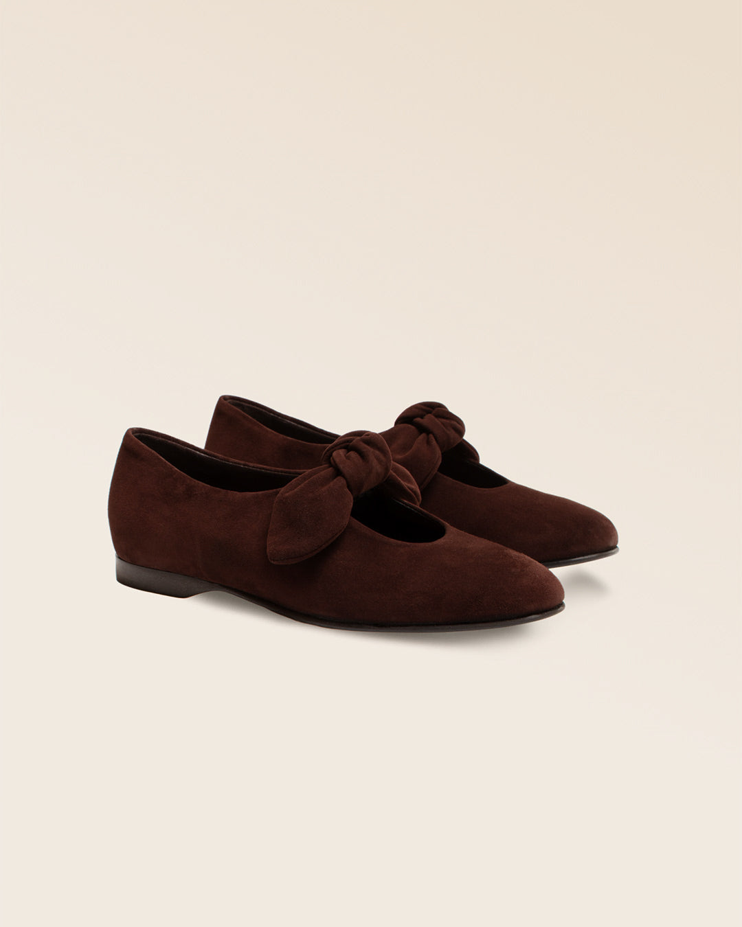 Nos babies Céleste Renouard en cuir nubuck chocolat et leur joli noeud sur le pied, vues de quart en studio.