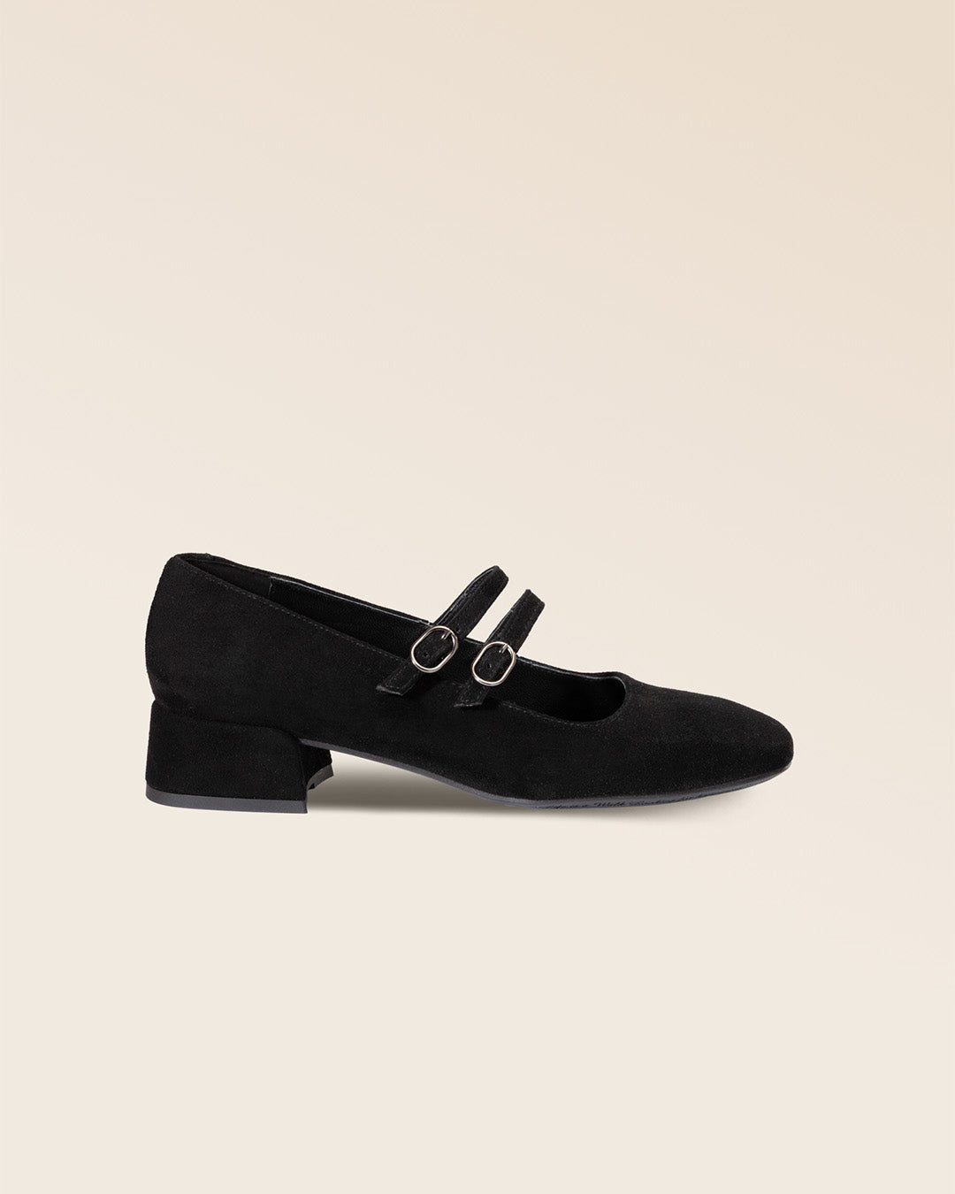 Nos babies Esmée Renouard en cuir nubuck noir et leur double bride sur le pied, vues de côté en studio.