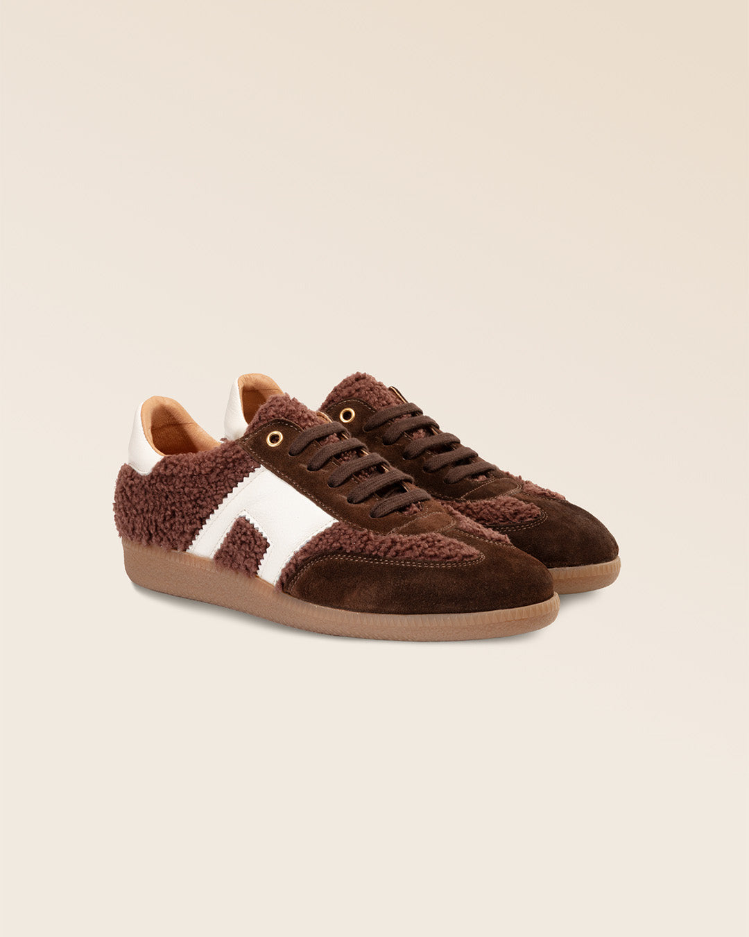 Nos sneakers Clara Renouard en cuir nubuck chocolat et bouclette bordeaux vues de quart en studio.