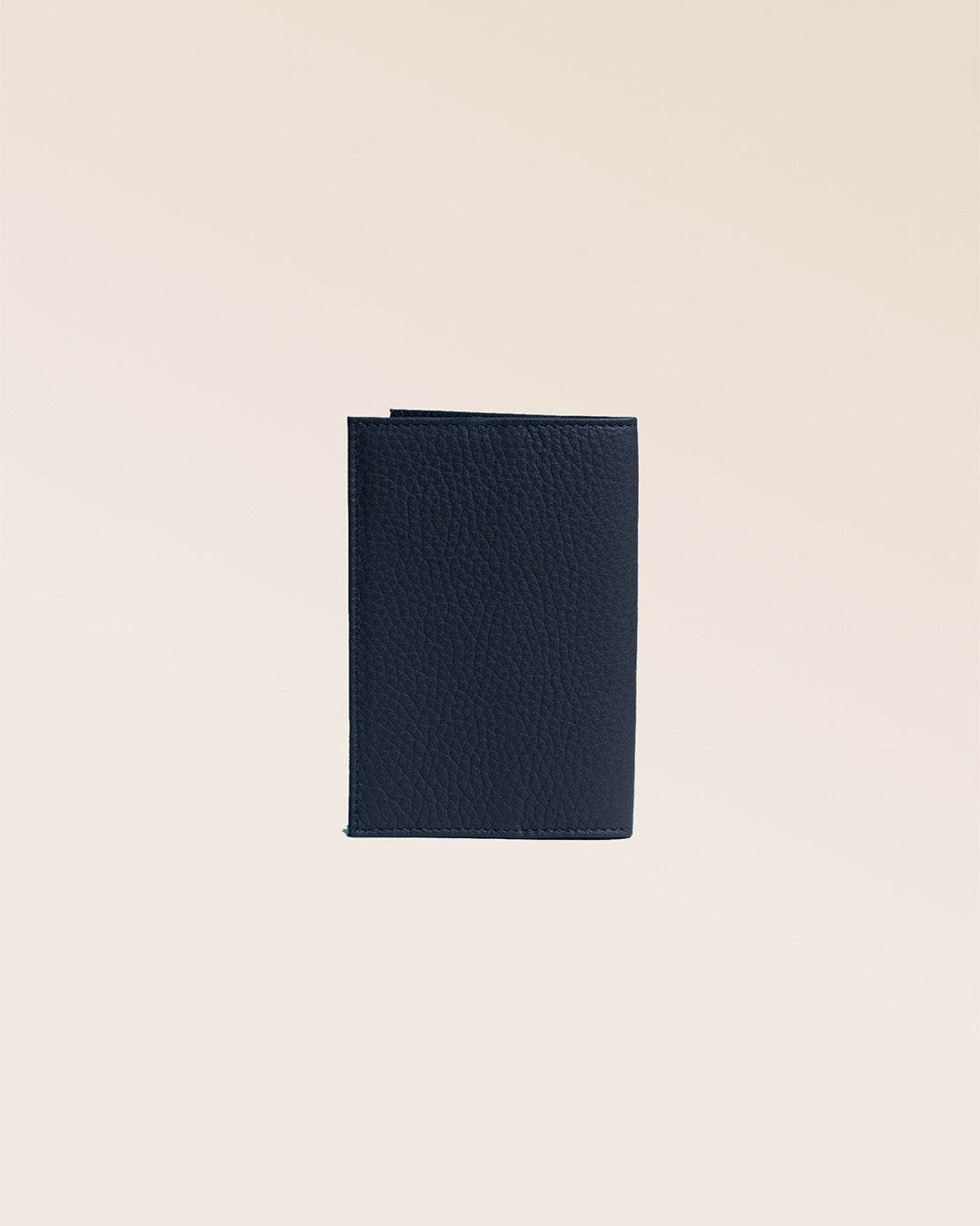 Our navy blue vicuña-style leather passport holder seen from the back in the studio.