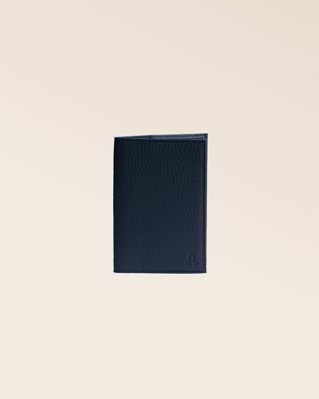 Our navy blue vicuña-style leather passport holder, seen from the front and closed in the studio.