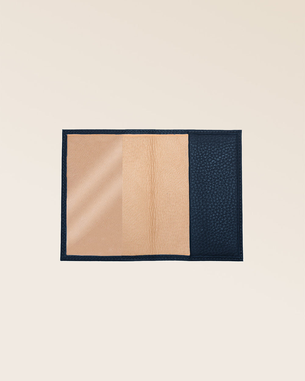 Notre étui passeport en cuir façon vigogne bleu marine vu de face ouvert en studio.