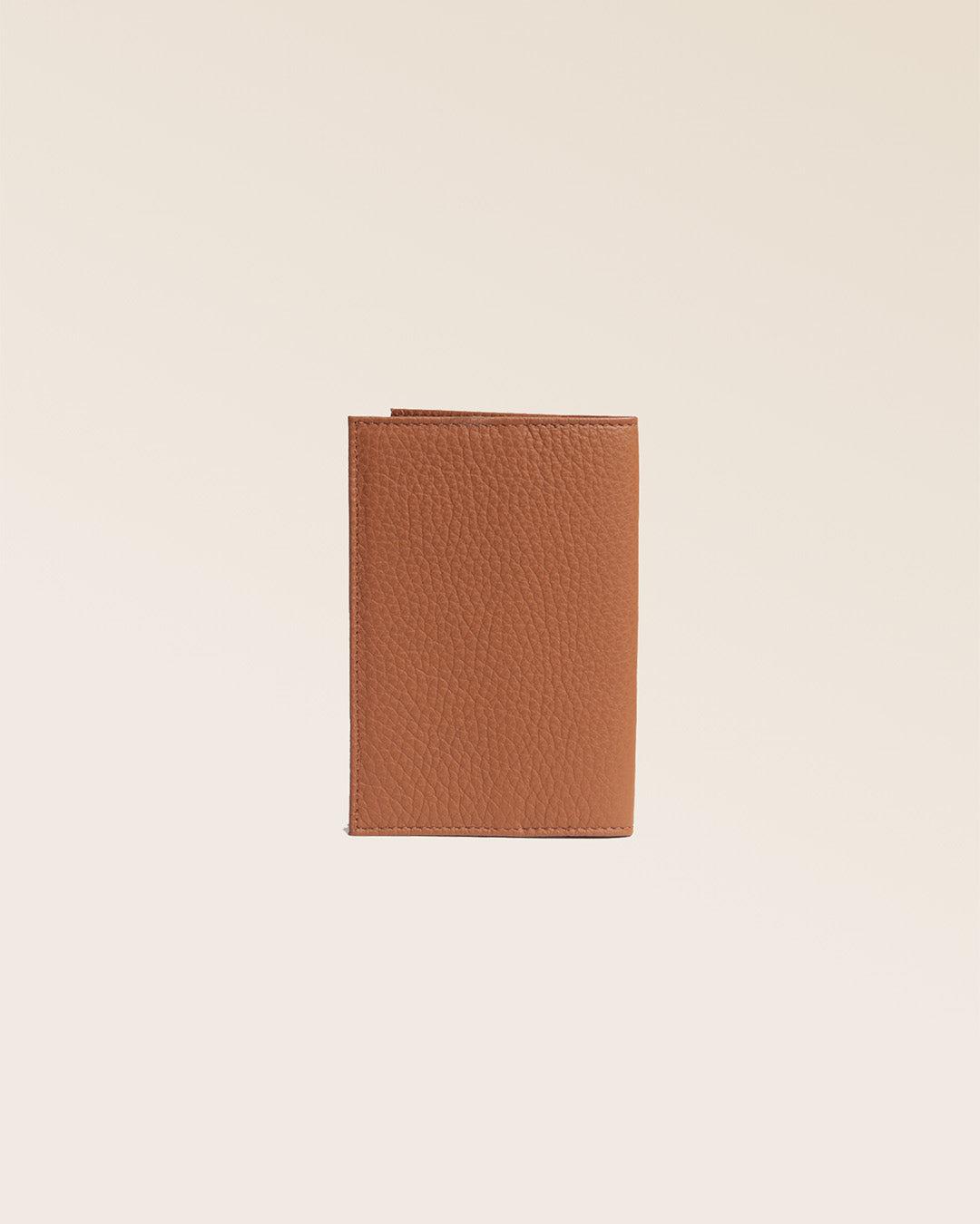 Notre étui porte passeport en cuir façon vigogne fauve vu de dos en studio.
