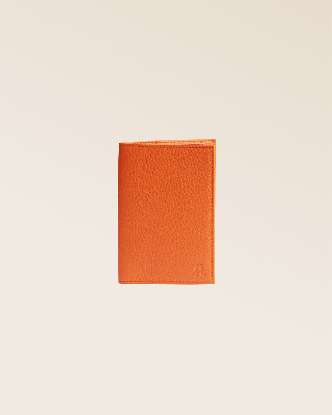 Notre étui passeport en cuir façon vigogne orange vu de face en studio.