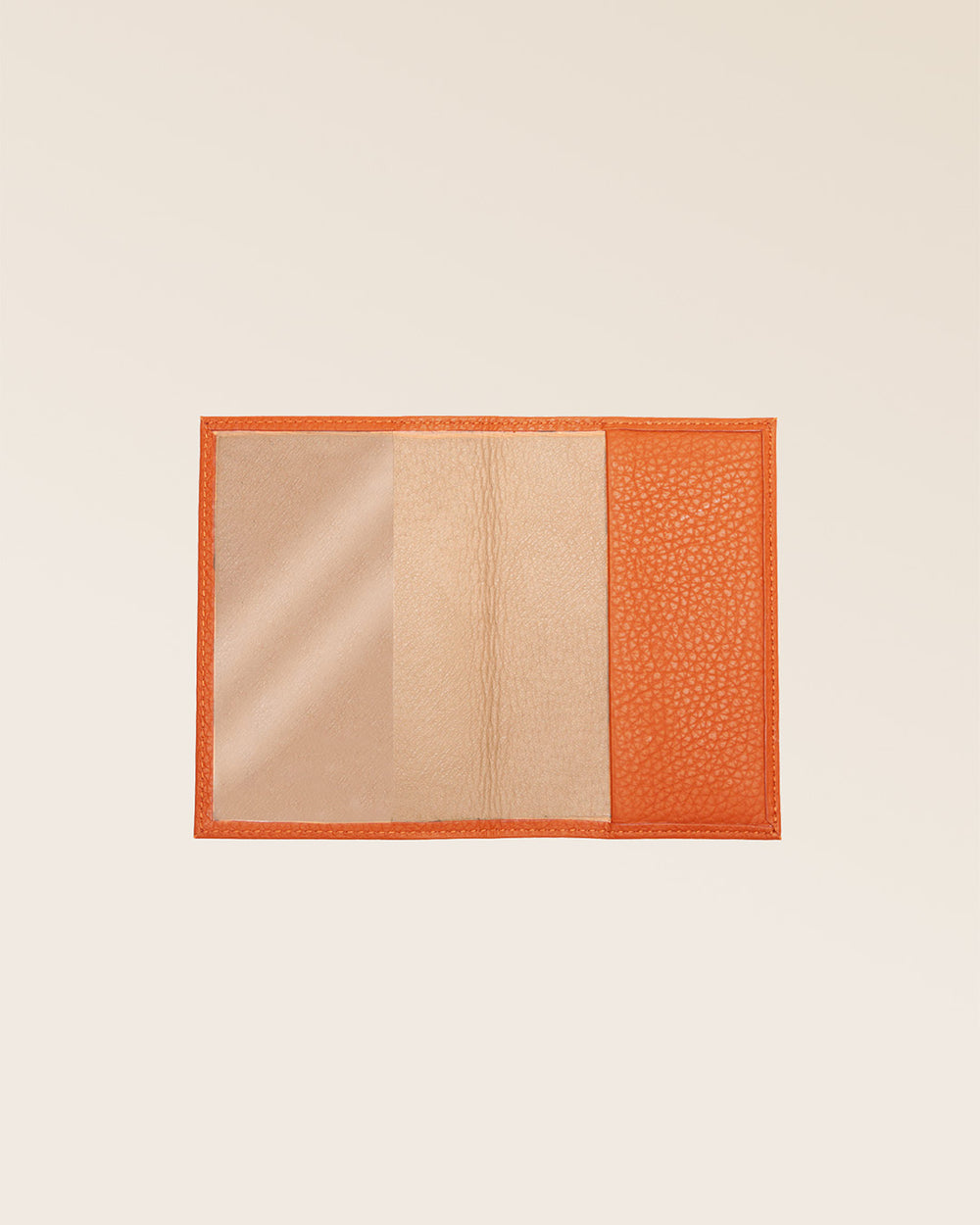 Notre étui passeport en cuir façon vigogne orange vu ouvert en studio.
