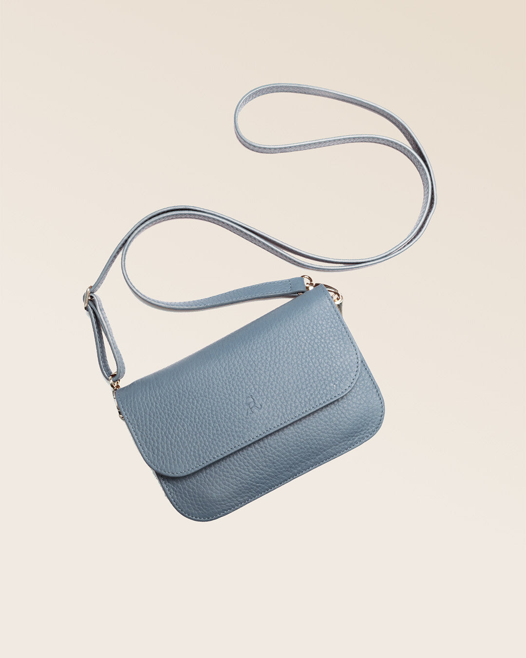 Notre pochette Coralie en cuir façon vigogne bleu cobalt vue de face à plat en studio.