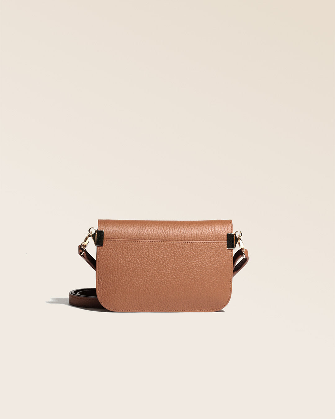 Notre pochette Coralie en cuir façon vigogne fauve vue de dos en studio.
