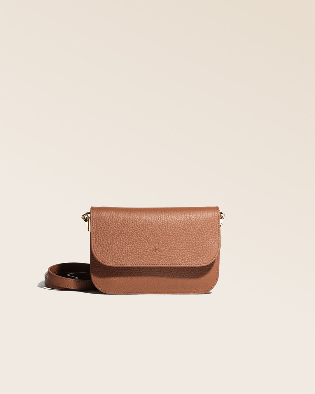 Notre pochette Coralie en cuir façon vigogne fauve vue de face en studio.