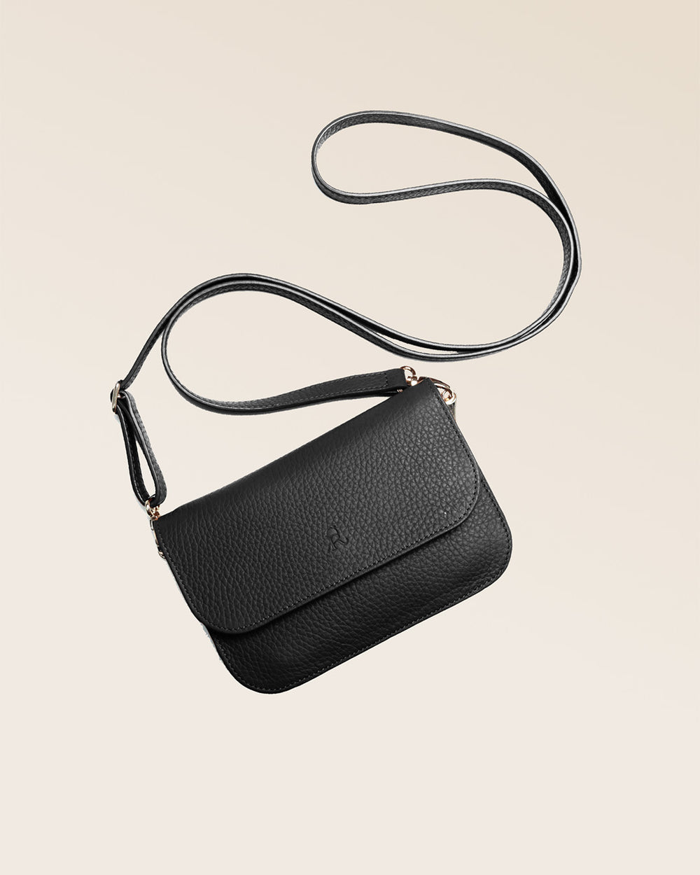 Notre pochette Coralie en cuir façon vigogne noir vue à plat  en studio.