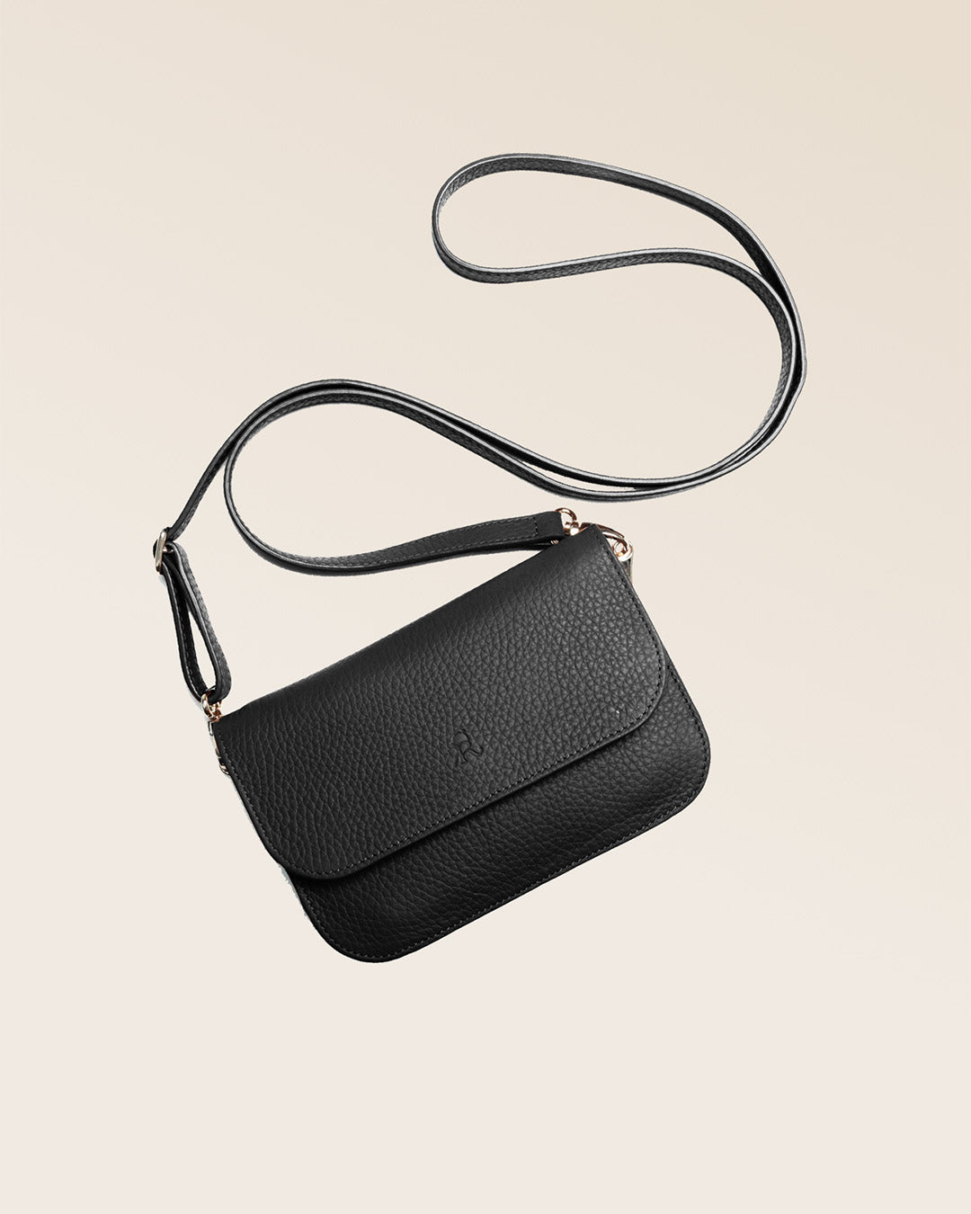 Notre pochette Coralie en cuir façon vigogne noir vue à plat en studio.