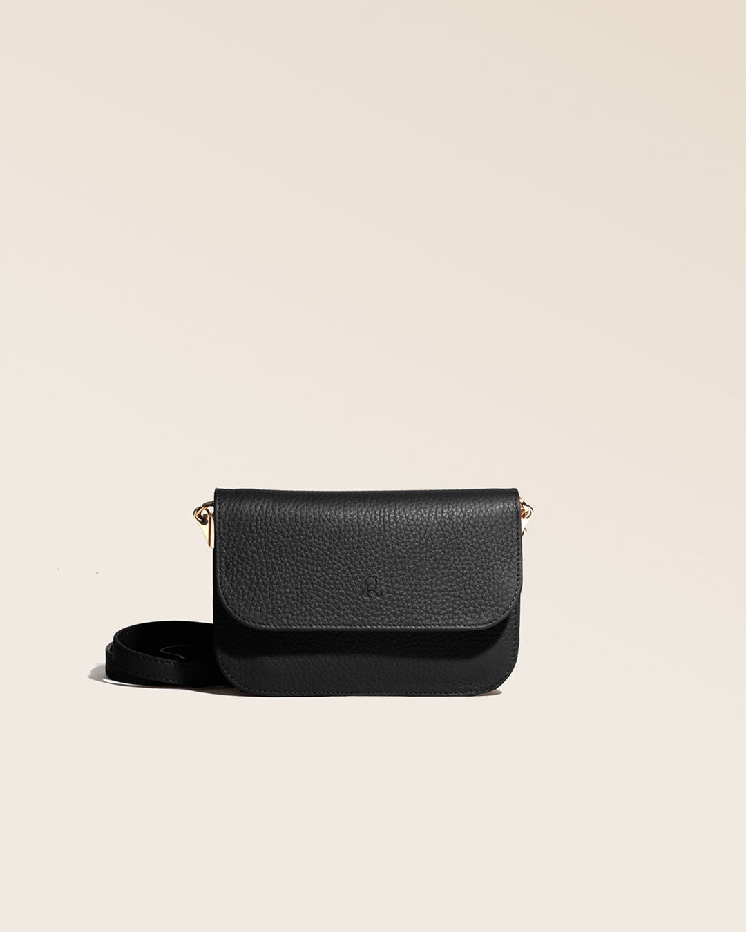 Notre pochette Coralie en cuir façon vigogne noir vue de face en studio.