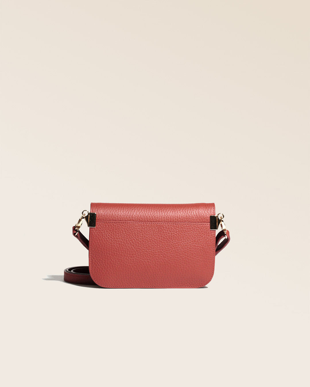 Notre pochette Coralie Renouard en cuir façon vigogne terracotta, vue de dos en studio.