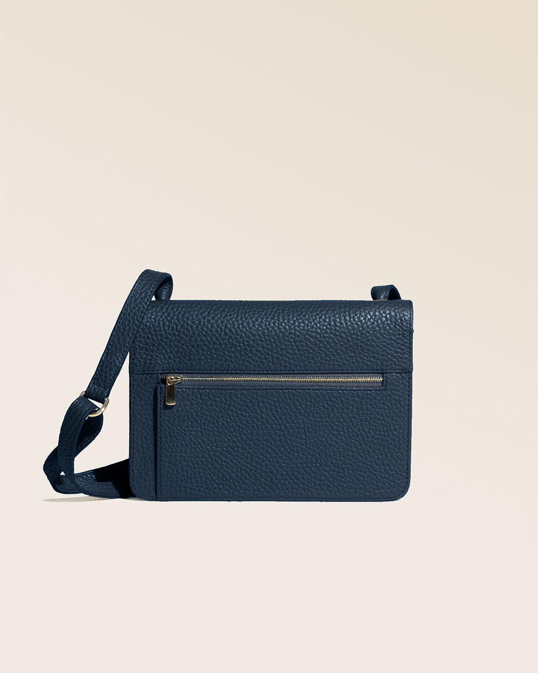 Notre pochette Frehel en cuir façon vigogne bleu marine vue de dos en studio.