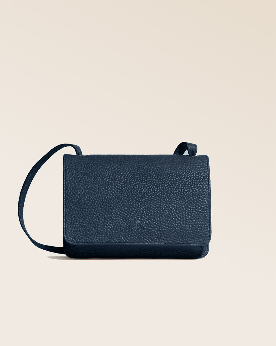 Notre pochette Frehel en cuir façon vigogne bleu marine vue de face en studio.