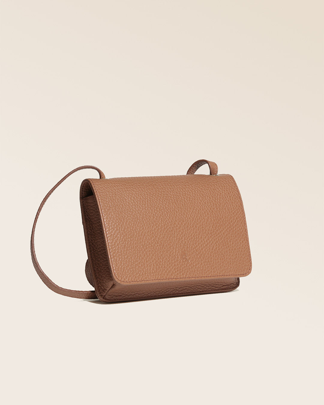 Our Fréhel clutch in fawn-colored vicuña leather, seen from the quarter in the studio.