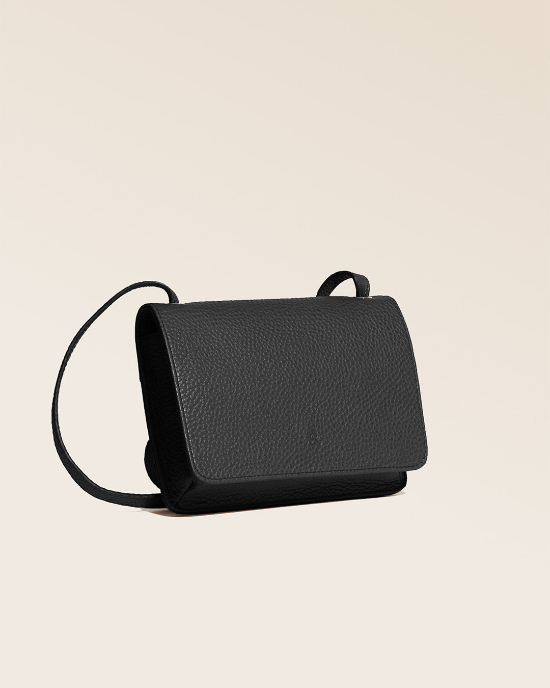 Our Frehel clutch in black vicuña-style leather, seen from the quarter in the studio.