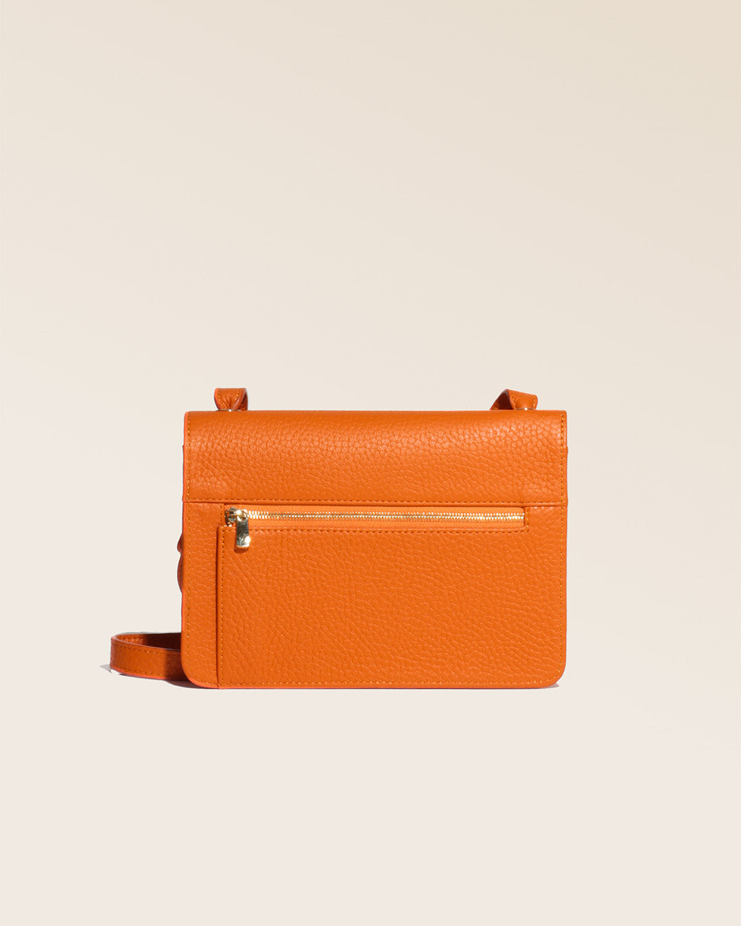 Our Fréhel clutch in orange vicuña-style leather, seen from the back in the studio.