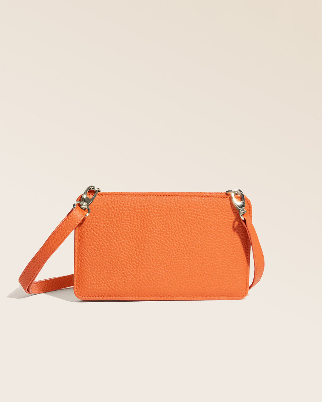 Notre pochette Manolo Renouard en cuir façon vigogne orange, vue de dos en studio.