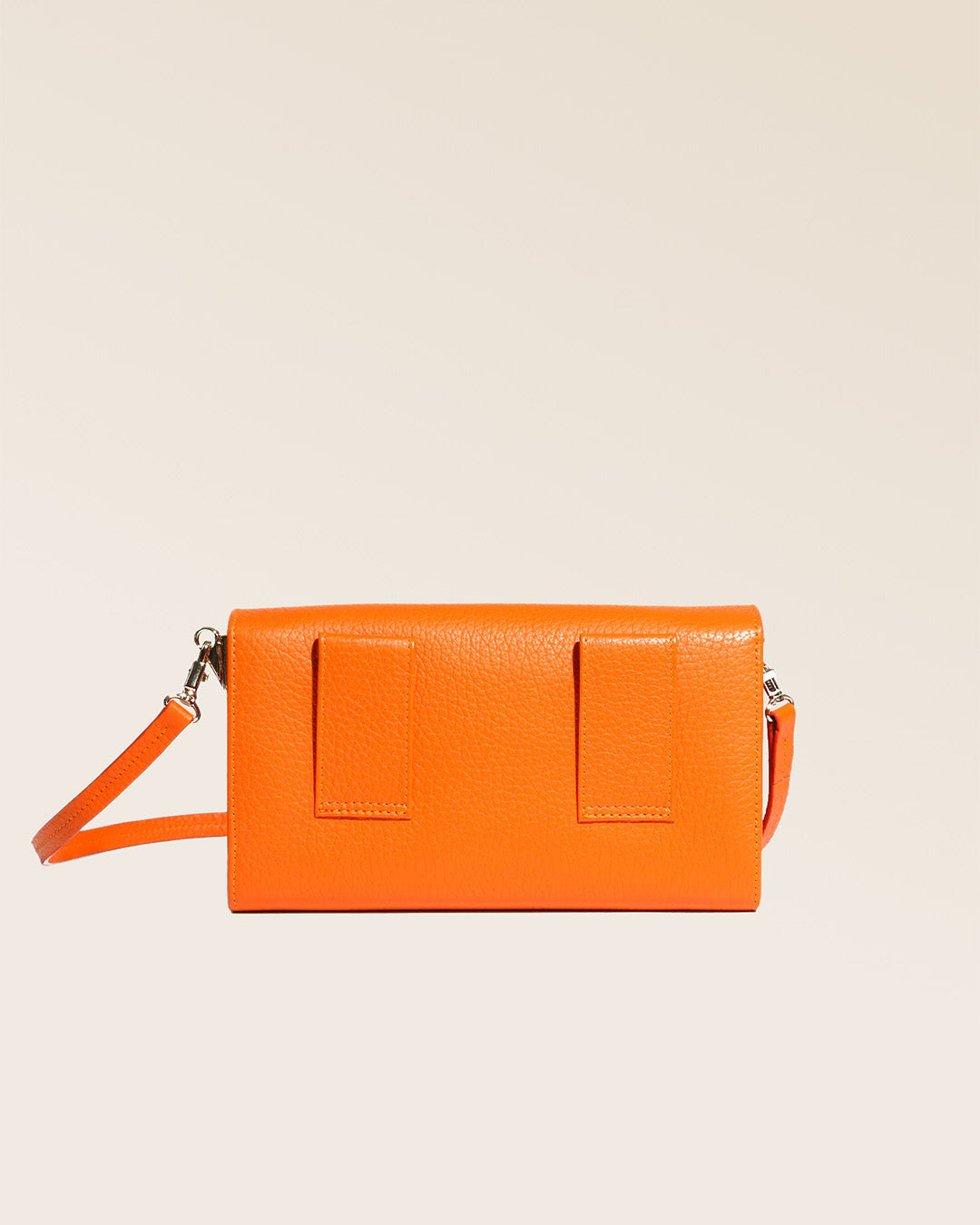 Notre pochette Raphaël en cuir façon vigogne orange vue de dos en studio.