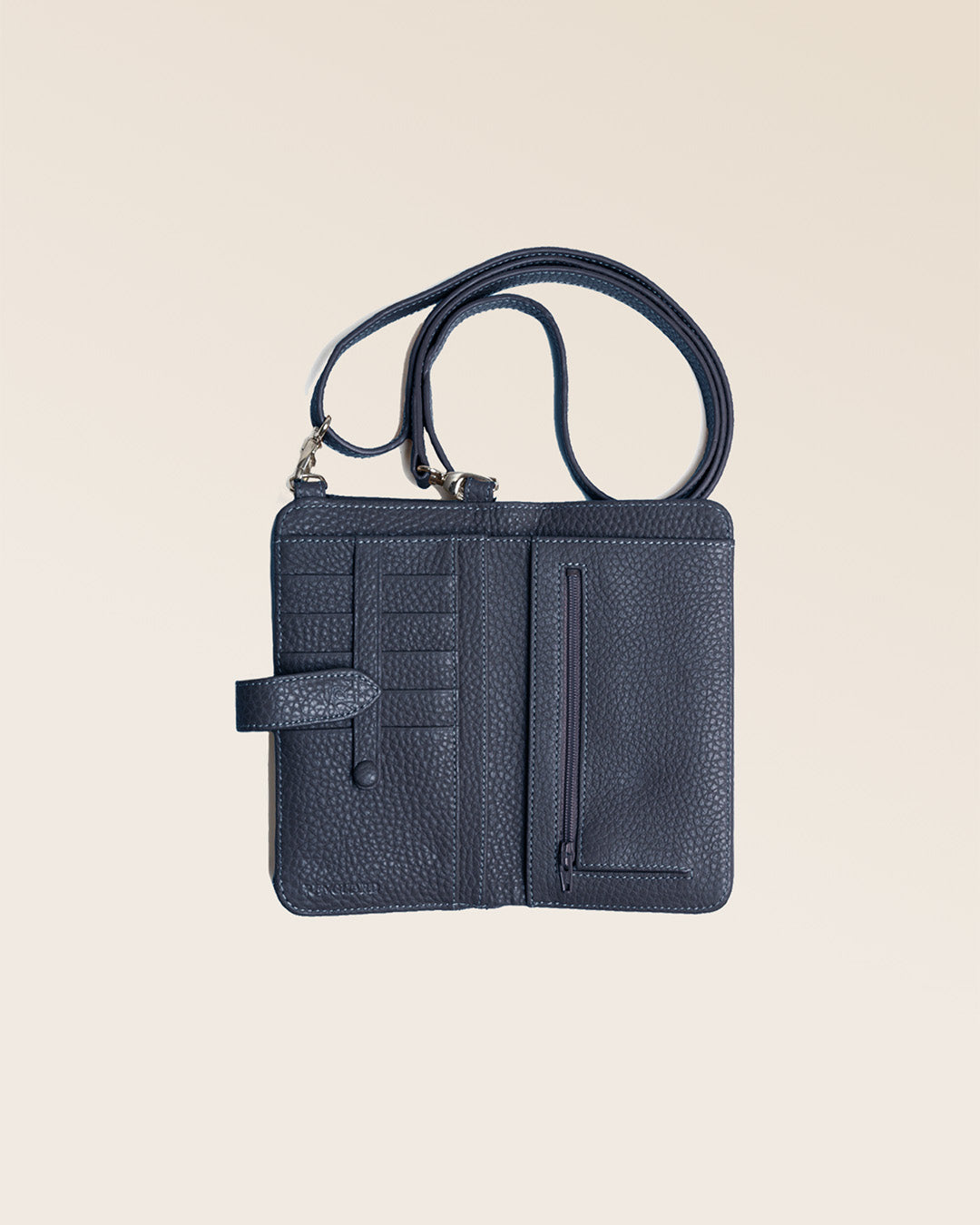 Notre pochette Tempo en cuir façon vigogne bleu marine vue du dessus en studio.