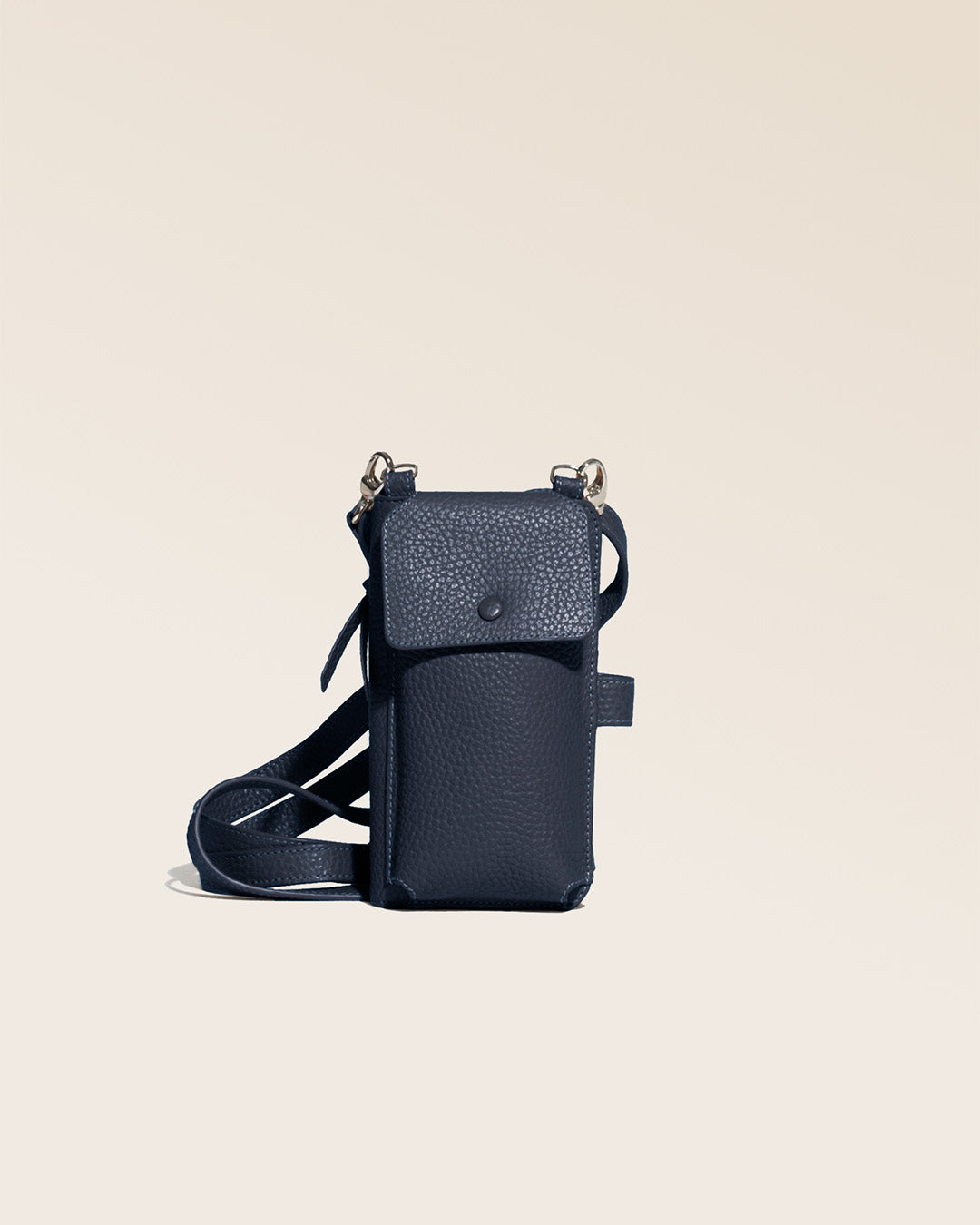 Notre pochette Tempo en cuir façon vigogne bleu marine vue de face en studio.