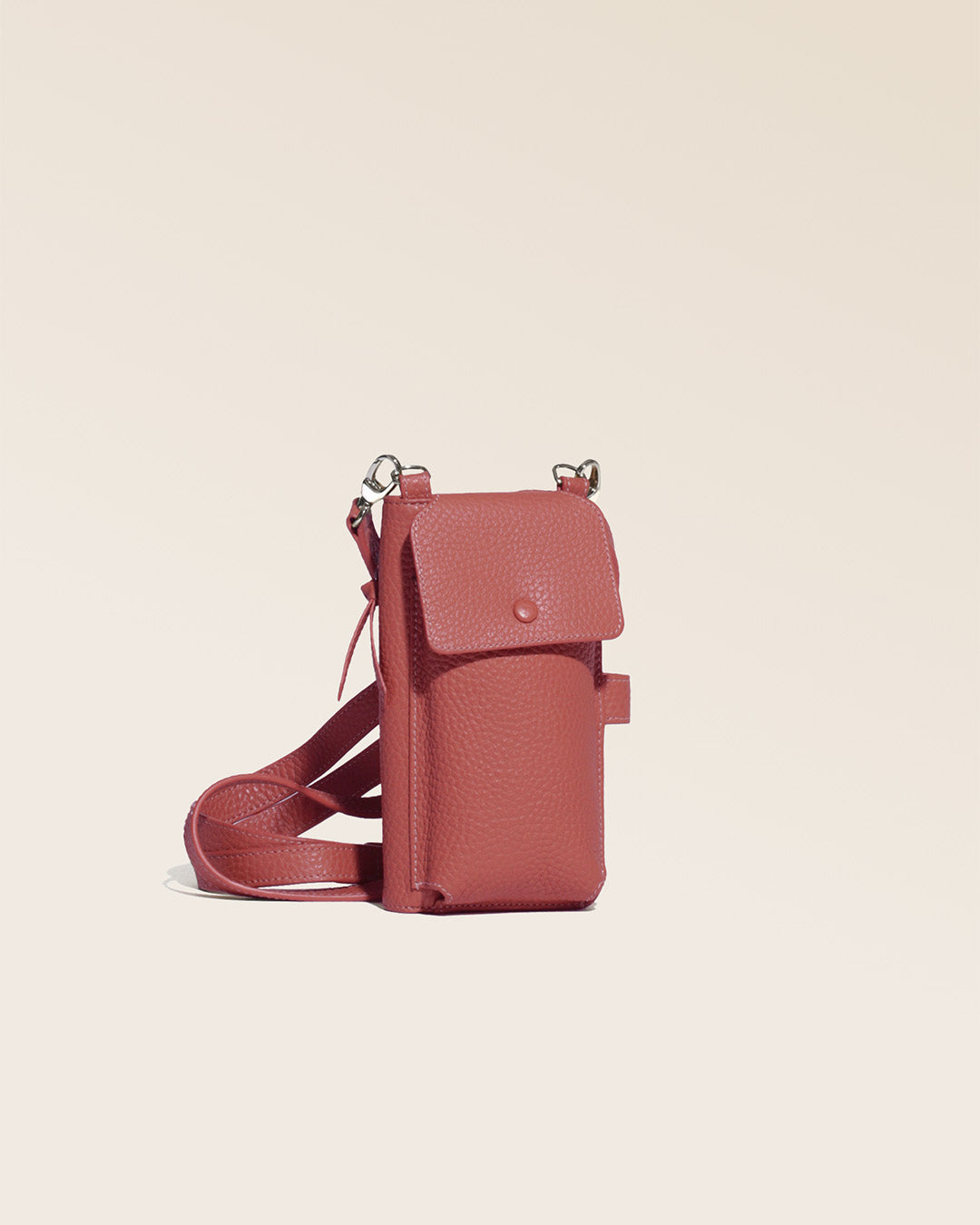 Our Tempo clutch bag in terracotta vicuña-style leather, seen from the quarter in the studio.