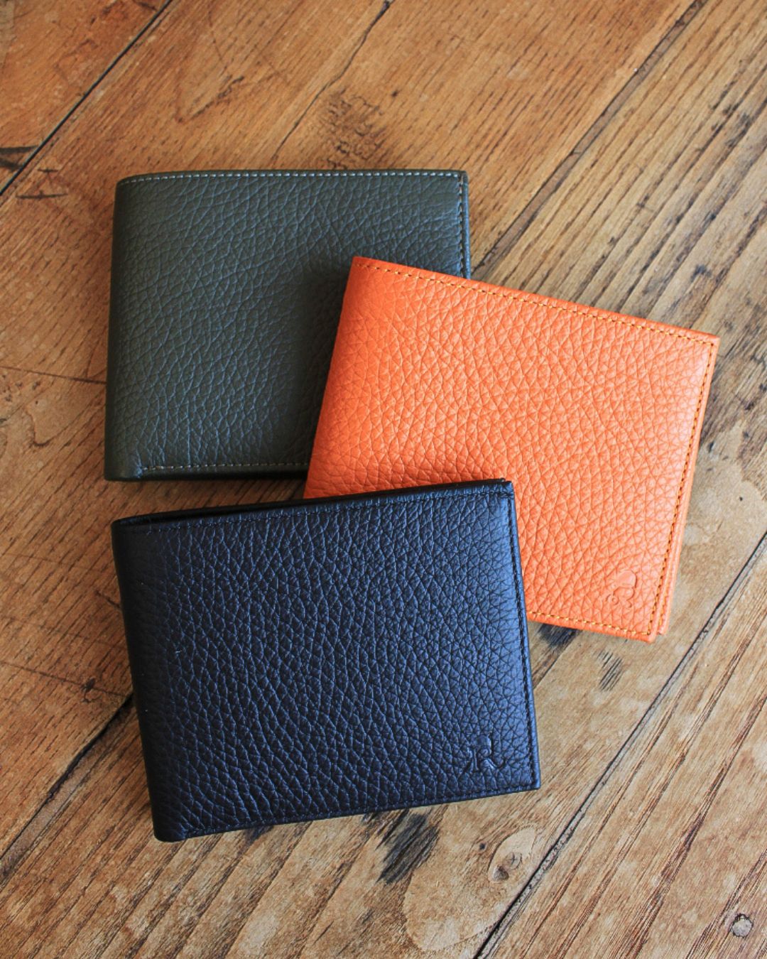 Notre porte-billets CB en cuir façon vigogne orange, kaki et noir vu de face en ambiance.