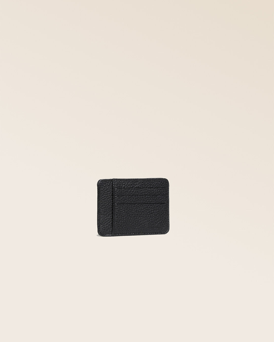 Our Adam cardholder in black vicuña-style leather, seen from the quarter in the studio.