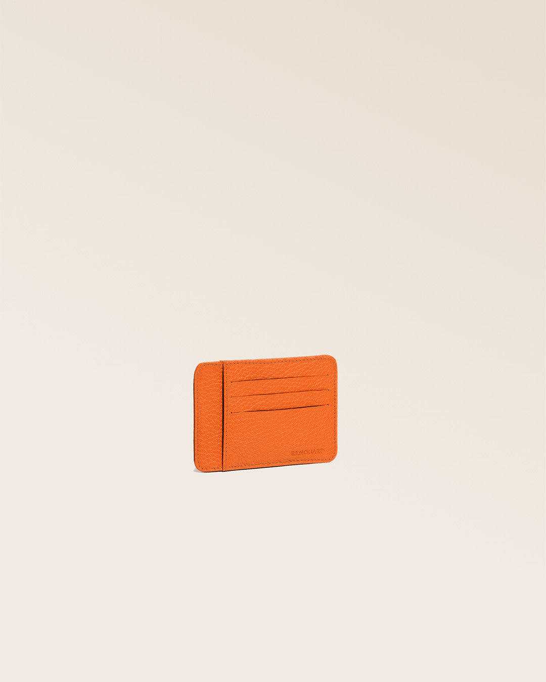 Our orange vicuña-style leather Adam cardholder seen from the quarter in the studio.