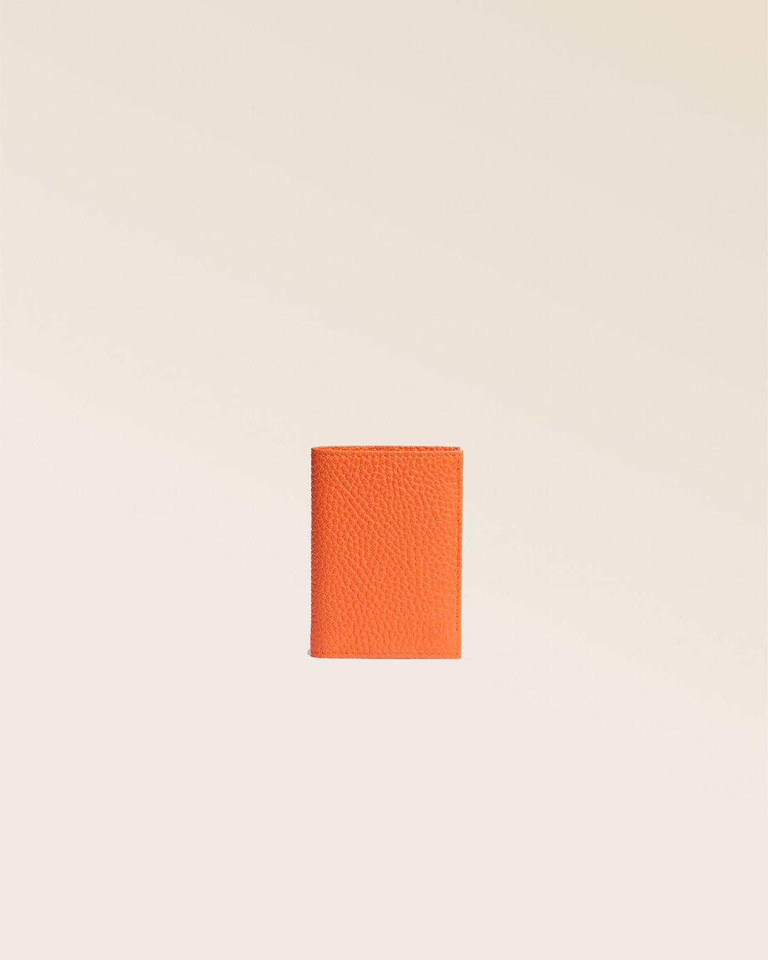 Notre porte-cartes Lucas en cuir façon vigogne orange vu de face en studio.
