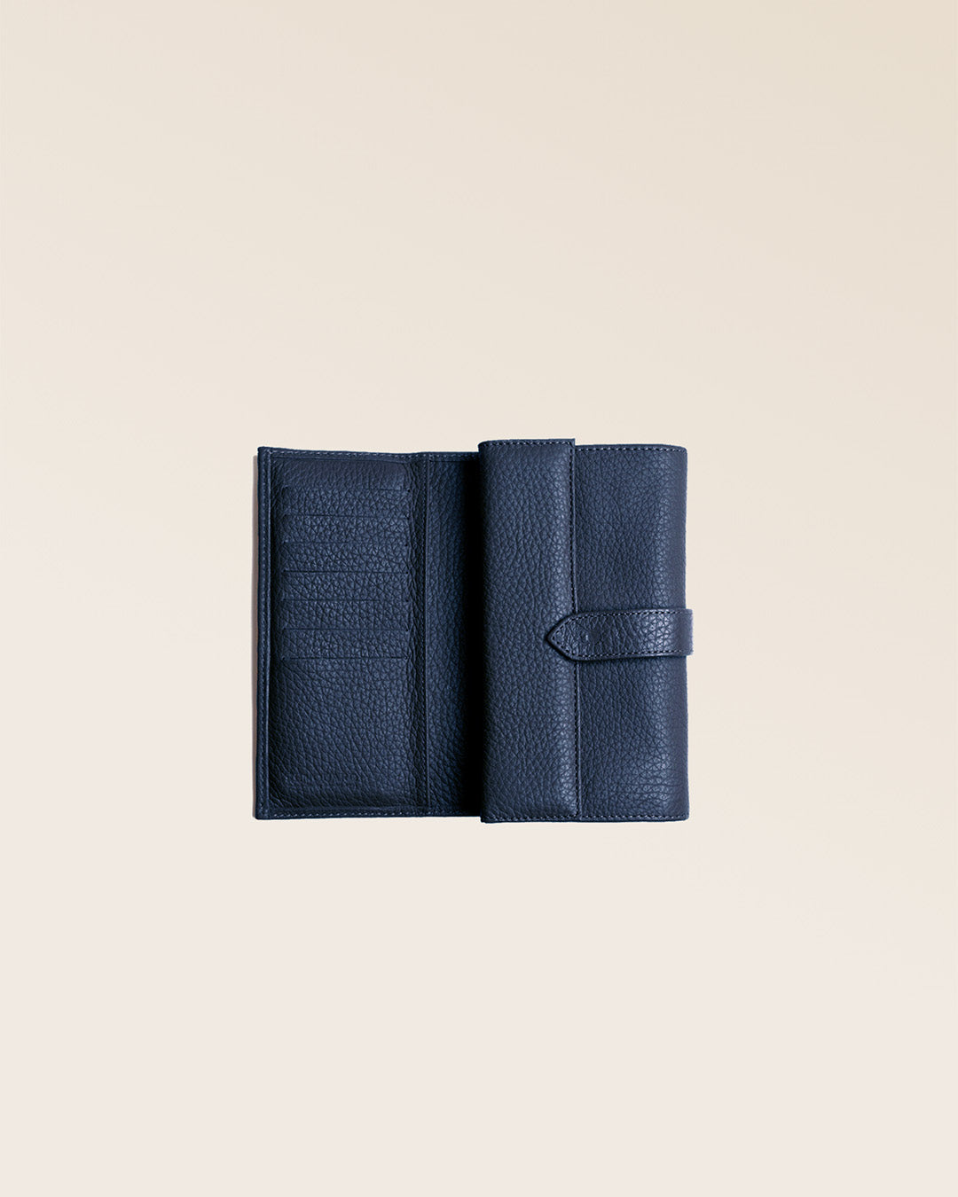 Our Adèle wallet in navy blue vicuña-style leather, seen open in the studio.