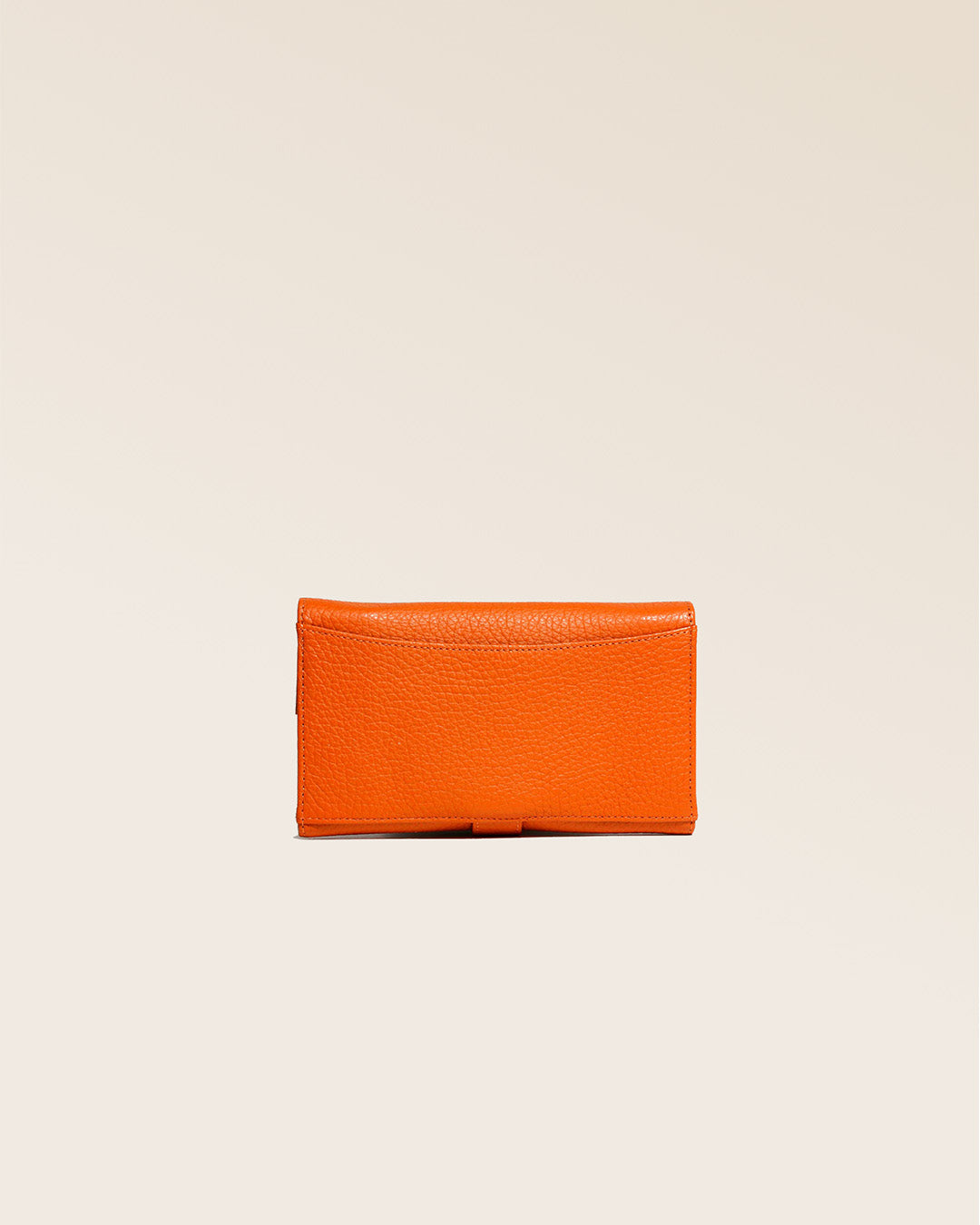 Notre porte-monnaie Adèle en cuir façon vigogne orange vu de dos en studio.