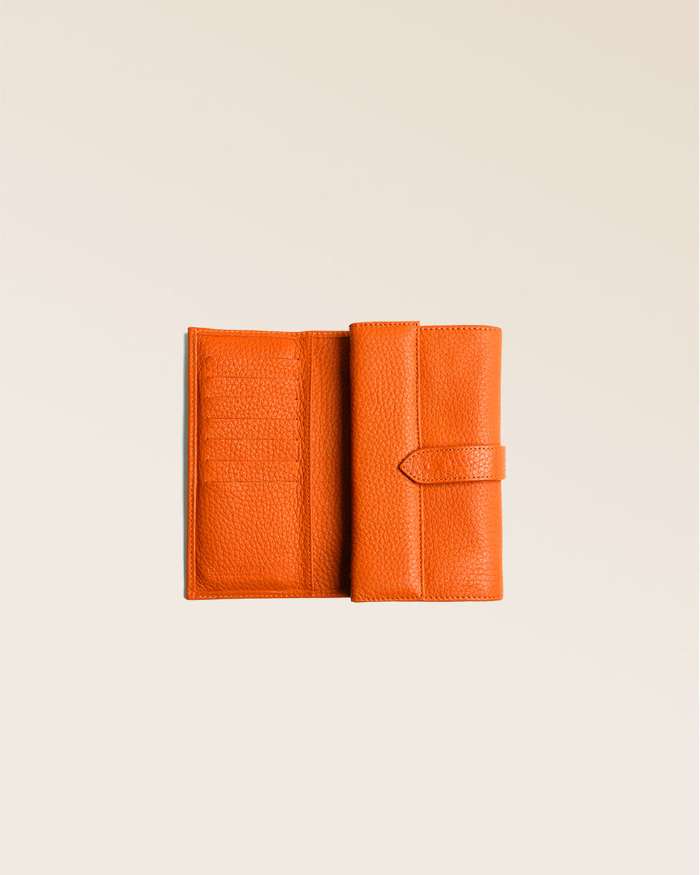 Notre porte-monnaie Adèle en cuir façon vigogne orange vu ouvert en studio.